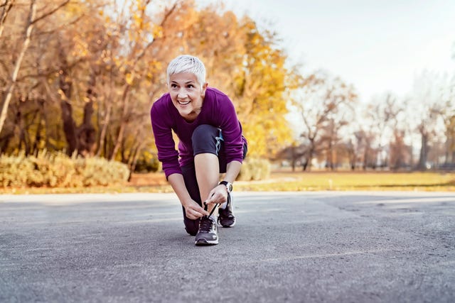 mujer atándose una zapatilla antes de salir a correr