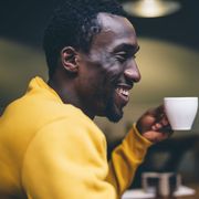 laughing man with cup of coffee in a coffee shop