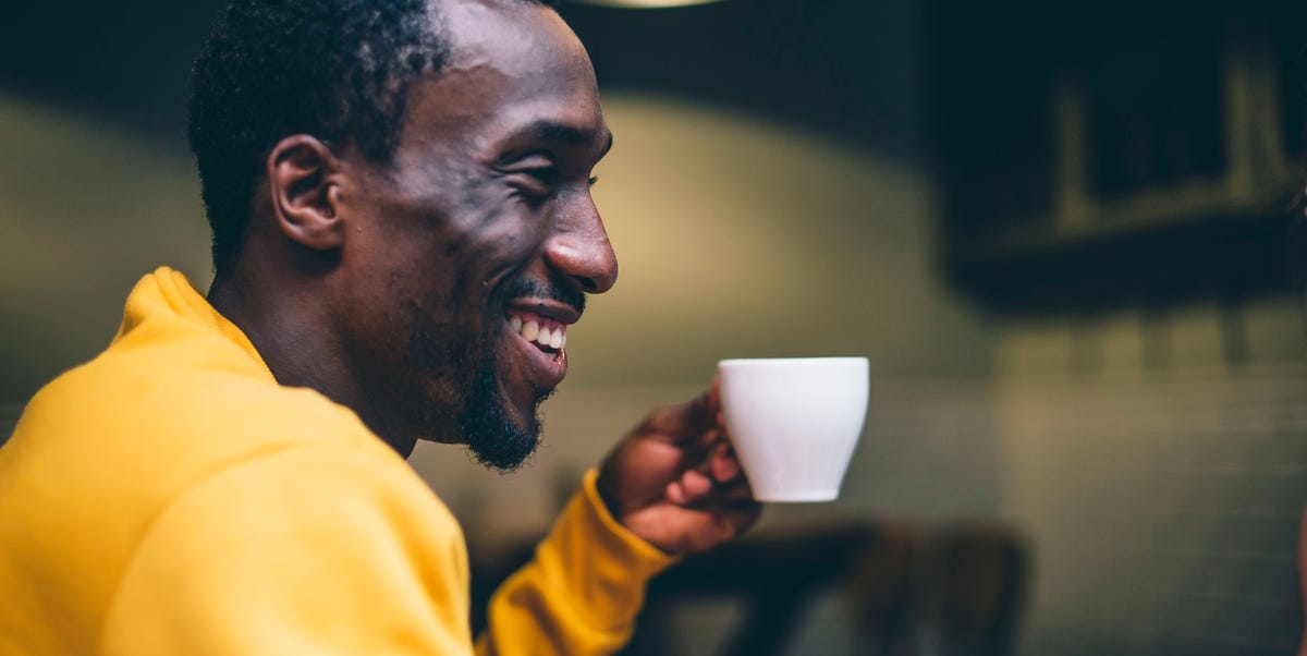 laughing man with cup of coffee in a coffee shop