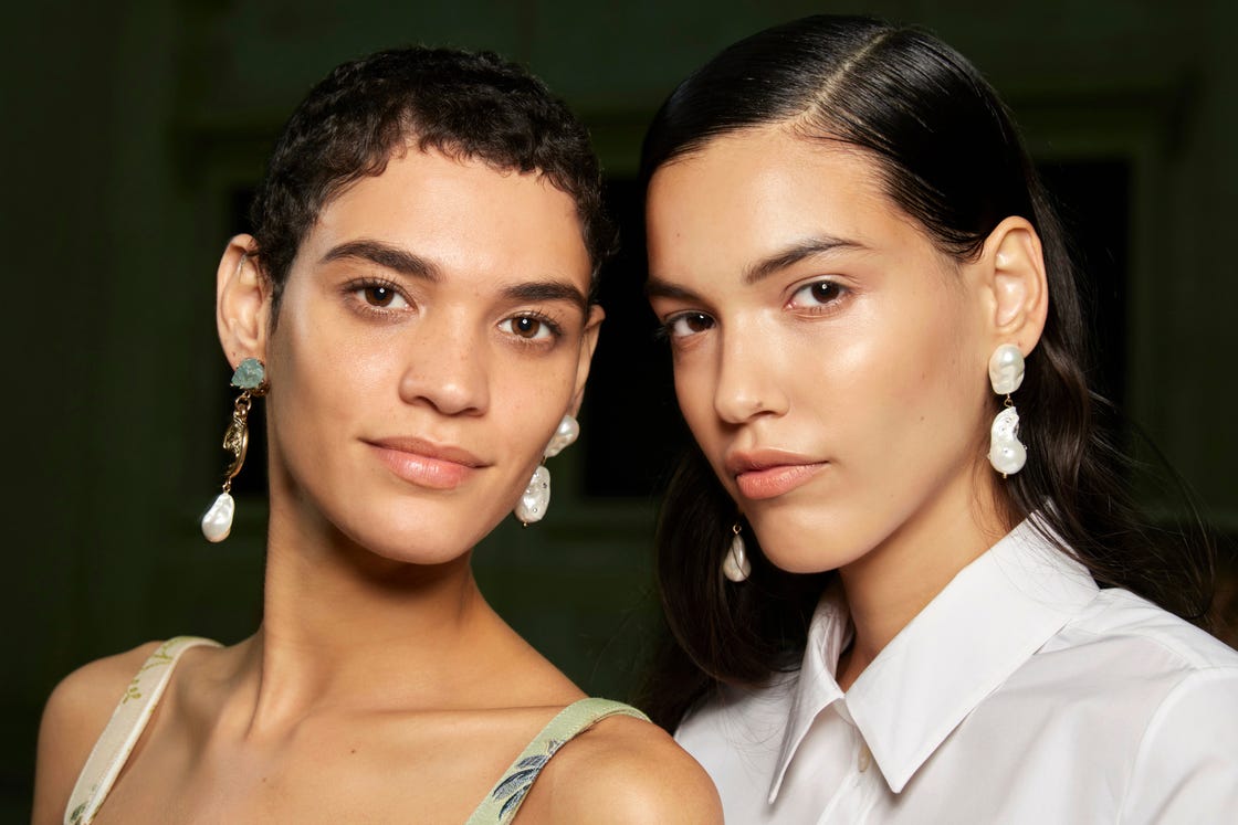 Two people wearing flashy earrings