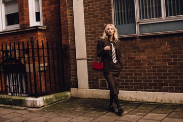 A person walking along a city street dressed in formal attire