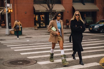 Two women walking on a city crosswalk in casual outfits