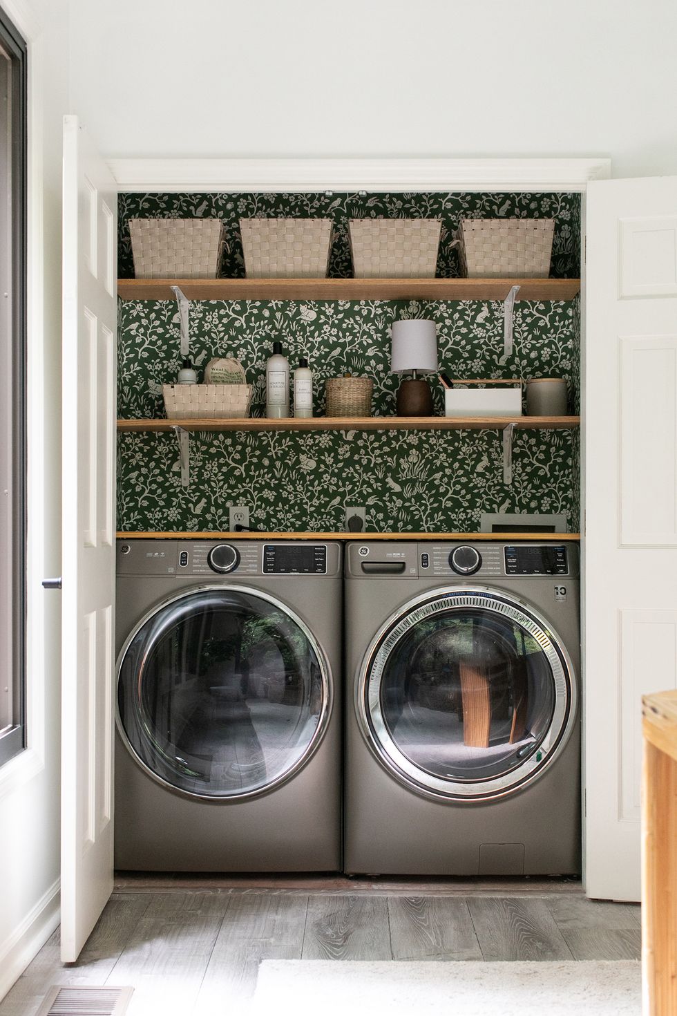a laundry room with a shelf with laundry and dryer