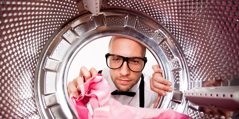 nerdy man peering into laundry machine