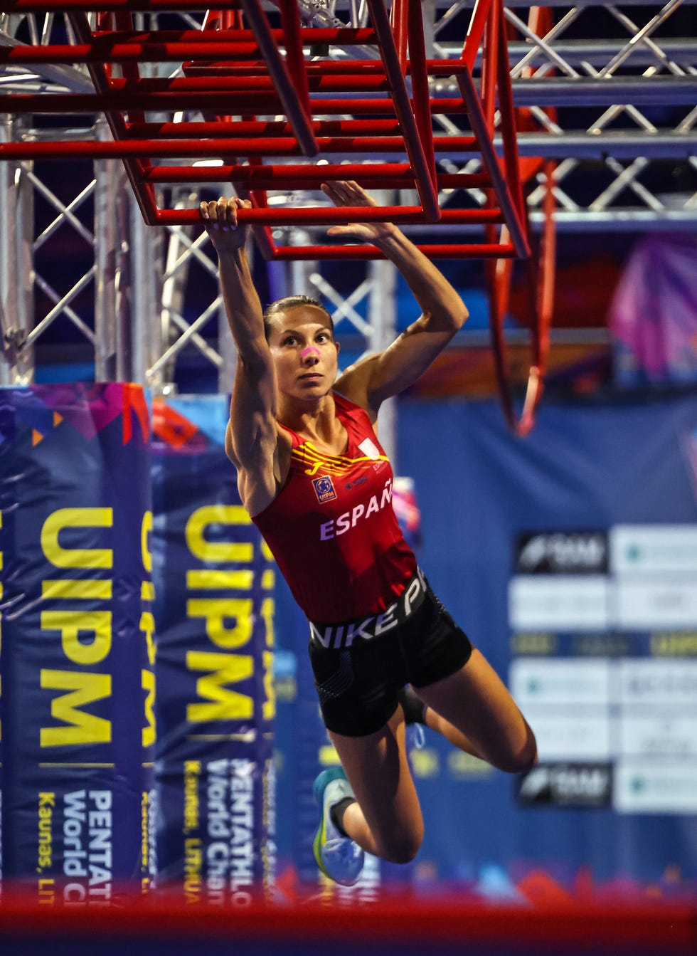 athlete performing gymnastic exercises on a hanging apparatus at a championship event