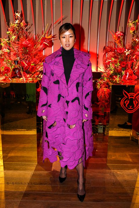 laura kim in a magenta coat with floral cut outs over a black turtleneck at a lunar new year's party in 2023
