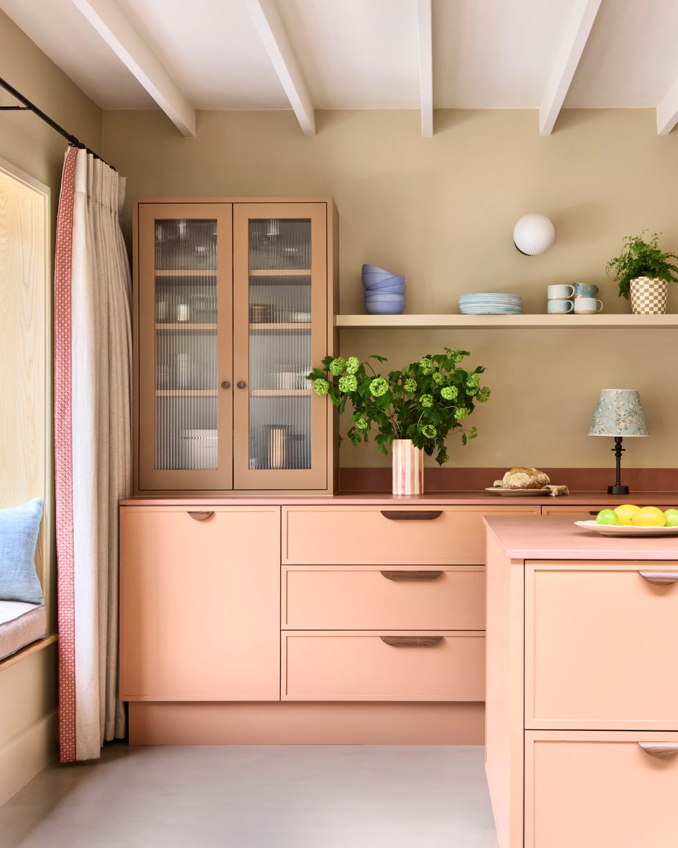 room with kitchen units white painted ceiling beams and a window seat with curtain