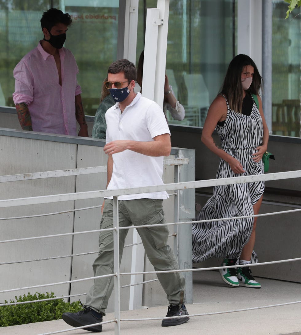 la hija de kiko matamoros, con un vestido de tirantes de print animal se toca la tripita y camina detrás de su pareja y delante de su hermano