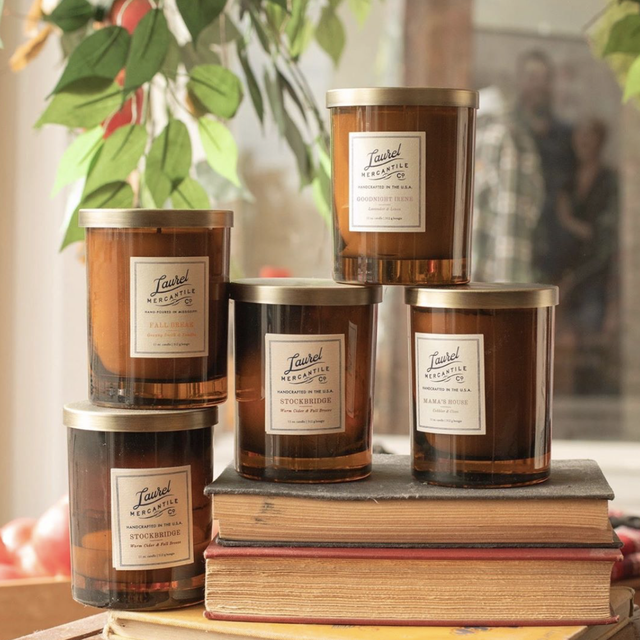 5 laurel mercantile fall candles displayed on books