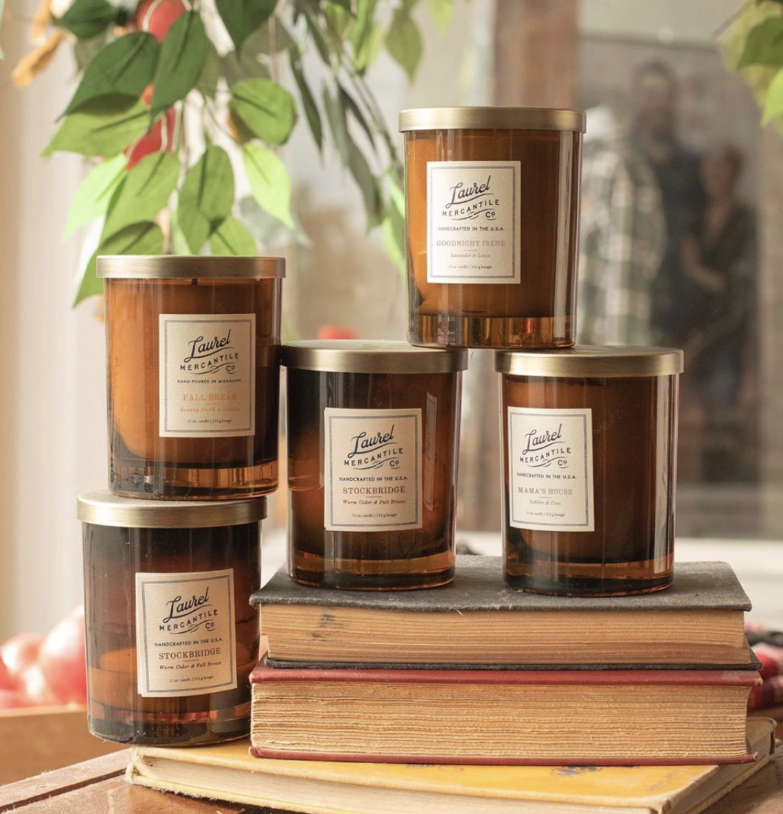 5 laurel mercantile fall candles displayed on books