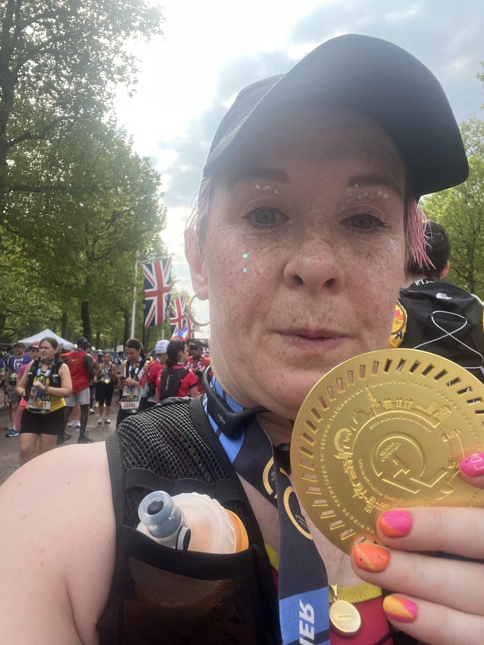 a runner poses with a london marathon finisher medal