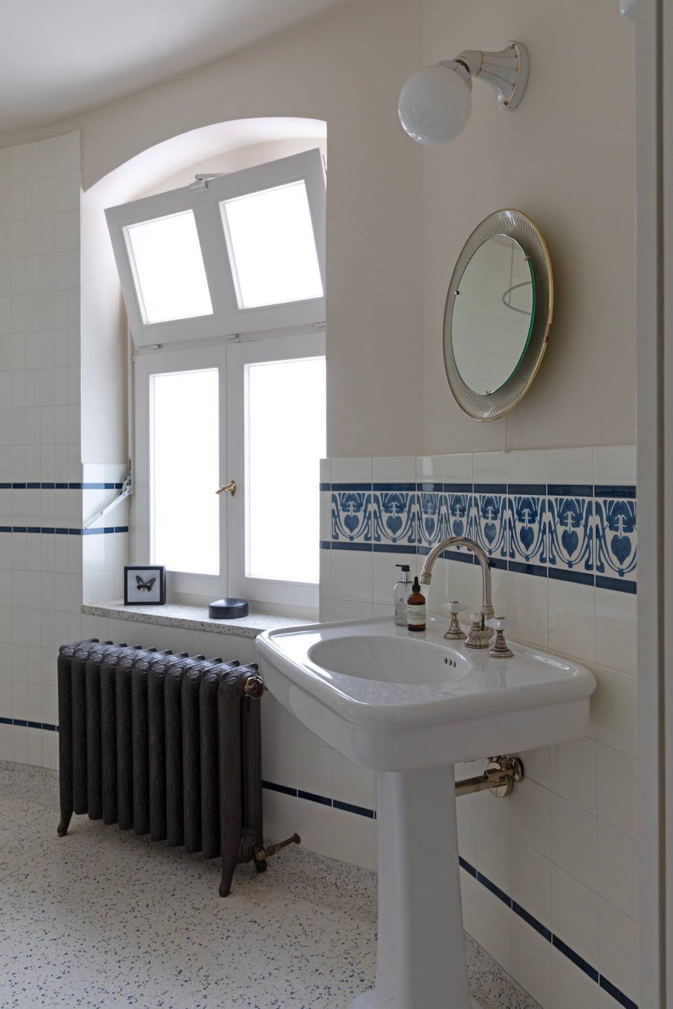aseo vintage con lavabo pedestal y radiador en hierro labrado.