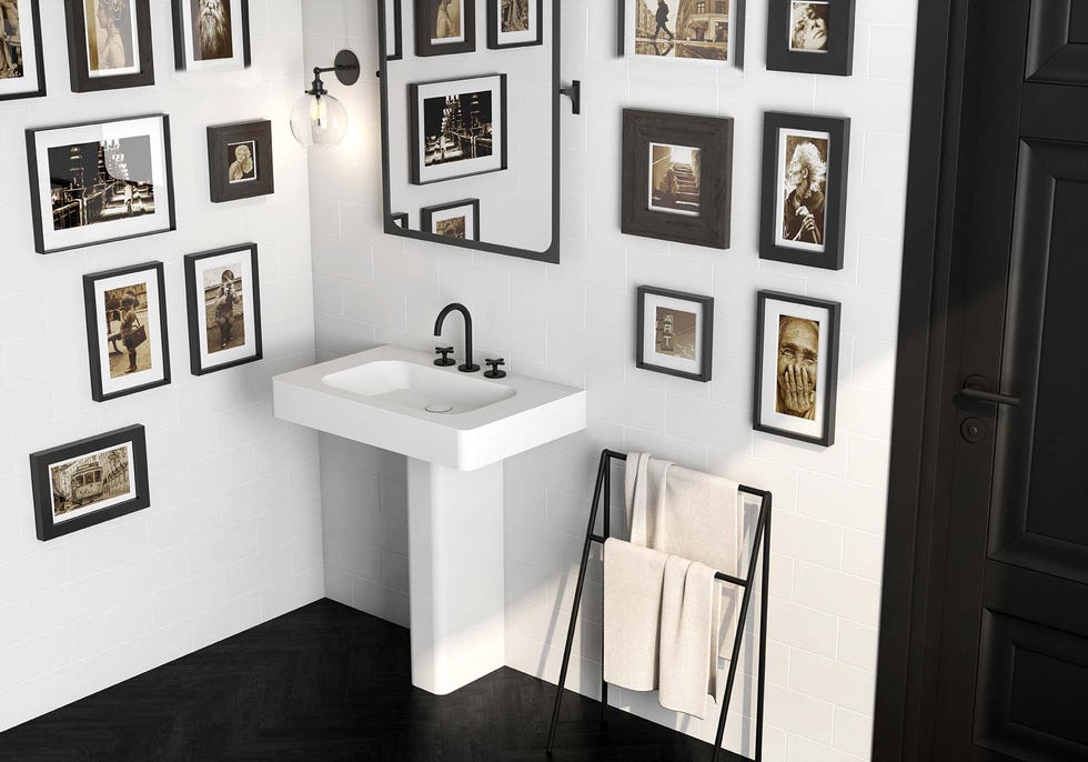 baño con lavabo de pedestal y decorado con cuadros