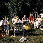 gathering of people in a yard sitting in vintage lawn chairs