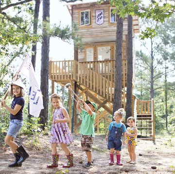 kids in front of a wood tree house