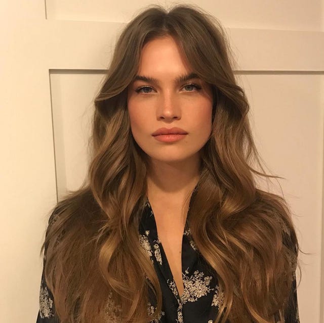 a women on the left on a gray background with curly layered hair and a women on the right in front of a white door with long brown layered hair