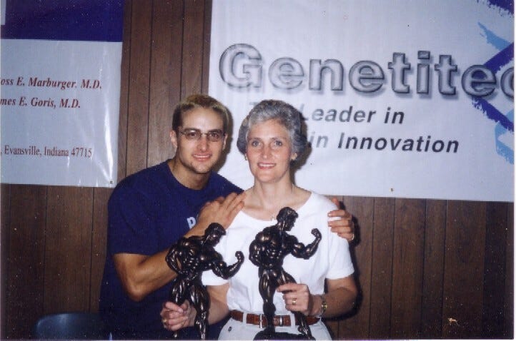 two individuals holding trophies representing bodybuilding achievements