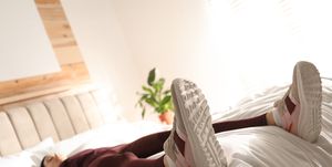 lazy young woman sleeping on bed instead of morning training, focus on legs