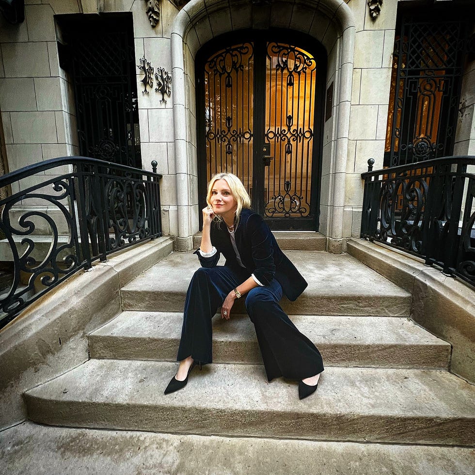 a person sitting on stone steps in front of a decorative doorway