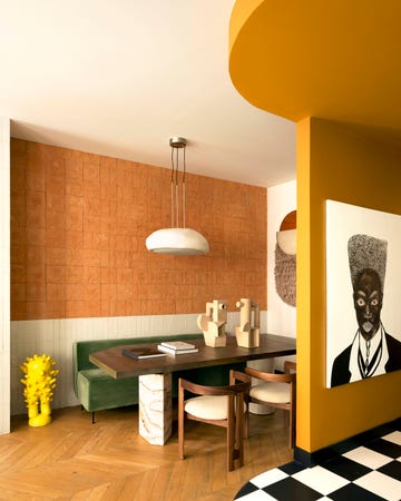 l'appartement inside de la décoratrice claude cartier, imaginé avec son collaborateur fabien louvier : salle à manger, soubassement en zelliges bernard ceramics, panneau mural en carreaux de terre cuite "giardino all'italiana" de cristina celestino pour fornace brioni, table "jupiter" de studiopepe en alpacca, marbre et ciment baxter, céramiques "pablo et dora" tacchini, tapisserie murale " talisman" cc tapis, chaises "pigreco" de tobia scarpa tacchini, suspension "moonstone dome" giopato coombes, banquette "modern life sofa" de greta m. grossman gubi, sculpture de laurent dufour manifesta par laetitia moller