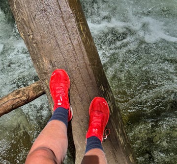 a person hiking across a log over water