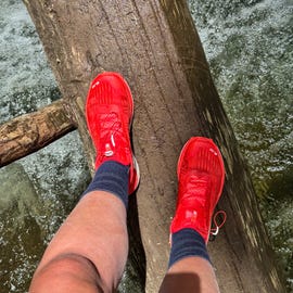 best hiking socks a person hiking across a log over water