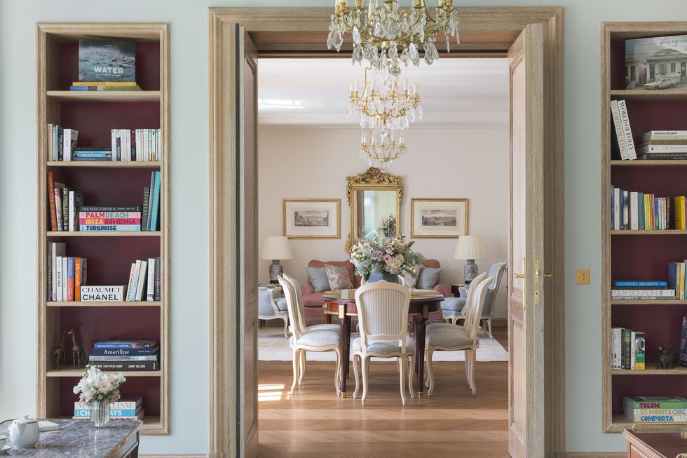 a dining room with a chandelier and bookshelves