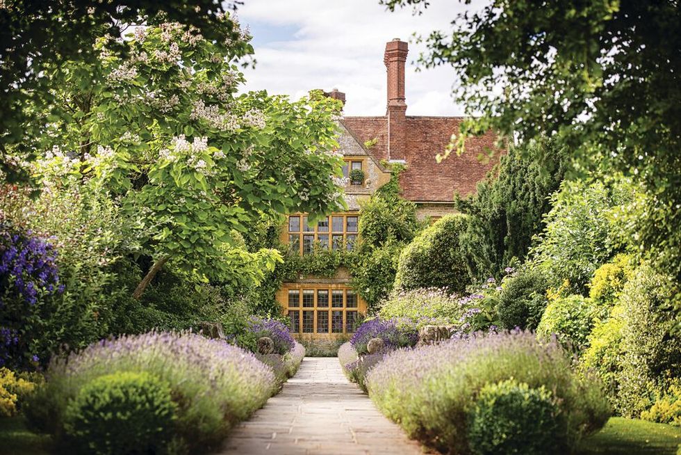 outside view of le manoir aux quat’saisons featuring a lush garden filled with bushes and plants