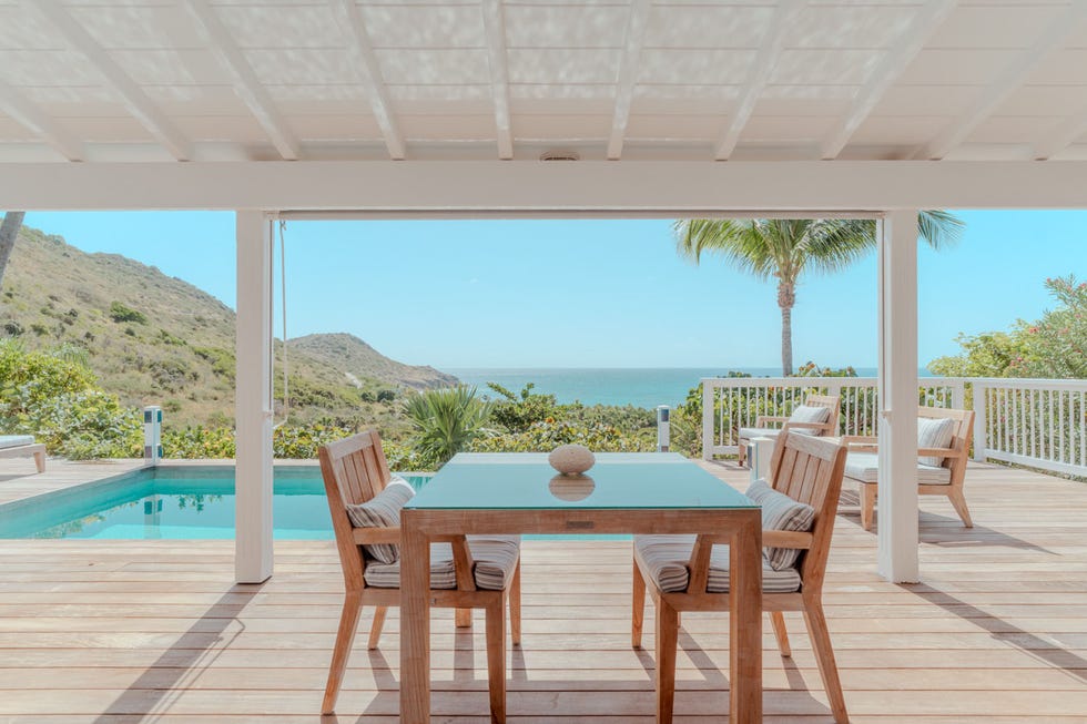 a dining area with a view overlooking a pool and ocean