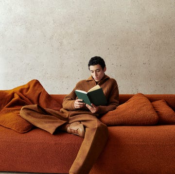 zegna model sitting on brown sofa