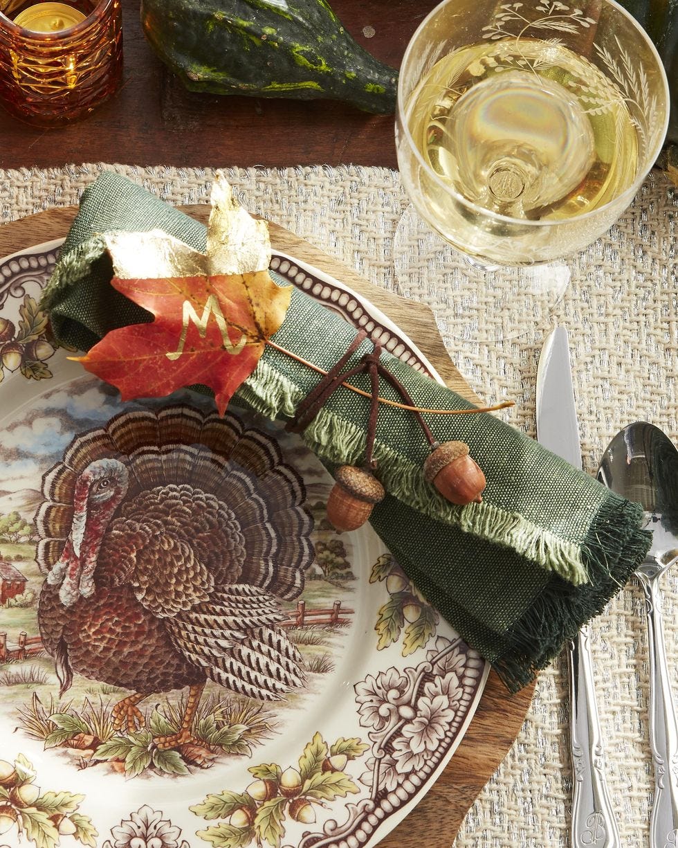 leaf crafts gold lead place card on the table by a green napkin and turkey designed plate
