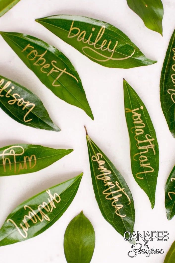leaf place cards with names written in gold lettering