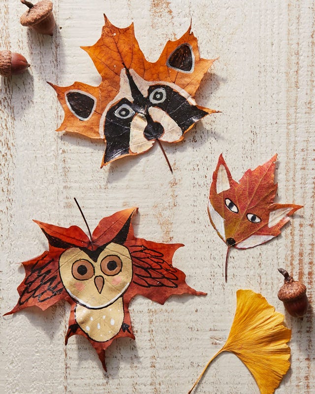 colorful fall leaves painted to look like animals layed out on a white surface