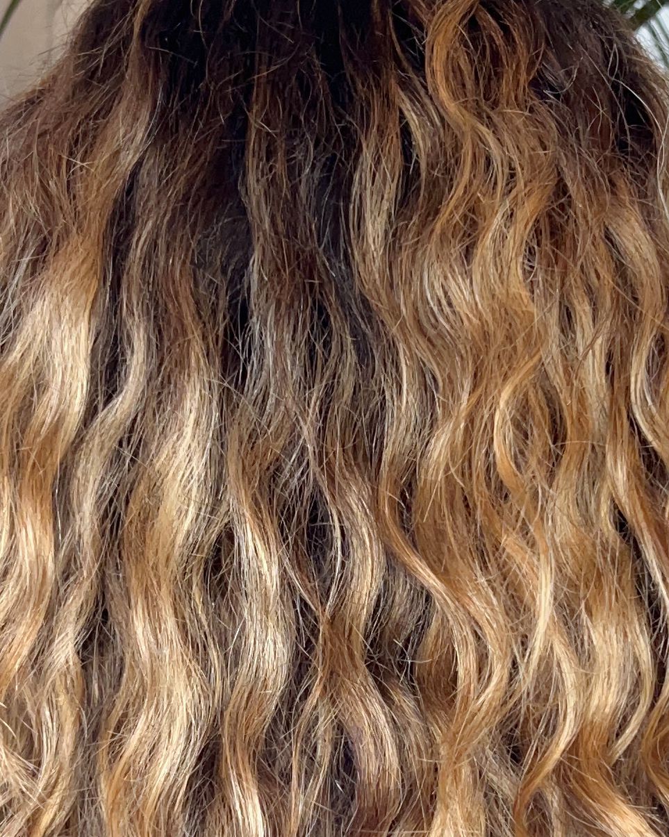 a person with long blonde wavy hair