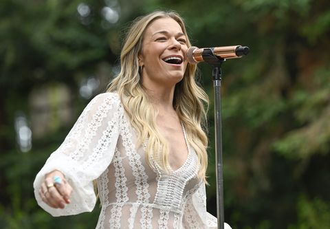 leann rimes sings on stage with mic in white lace dress