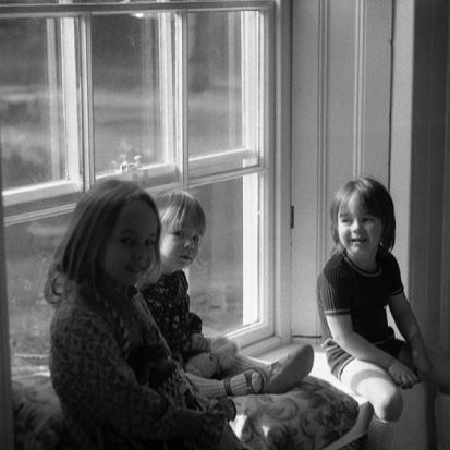 a group of girls sitting on a window sill