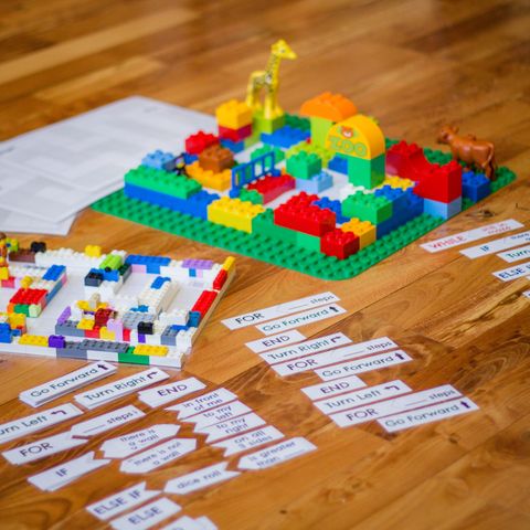 the pieces to a lego coding activity are spread out on a floor
