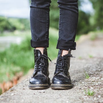 woman standing in park with leather boots