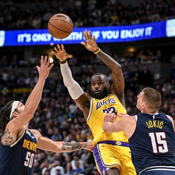 lebron james 23 of the los angeles lakers passes between the defense of aaron gordon 50 and nikola jokic 15 of the denver nuggets during the second quarter at ball arena in denver, colorado on monday, april 29, 202