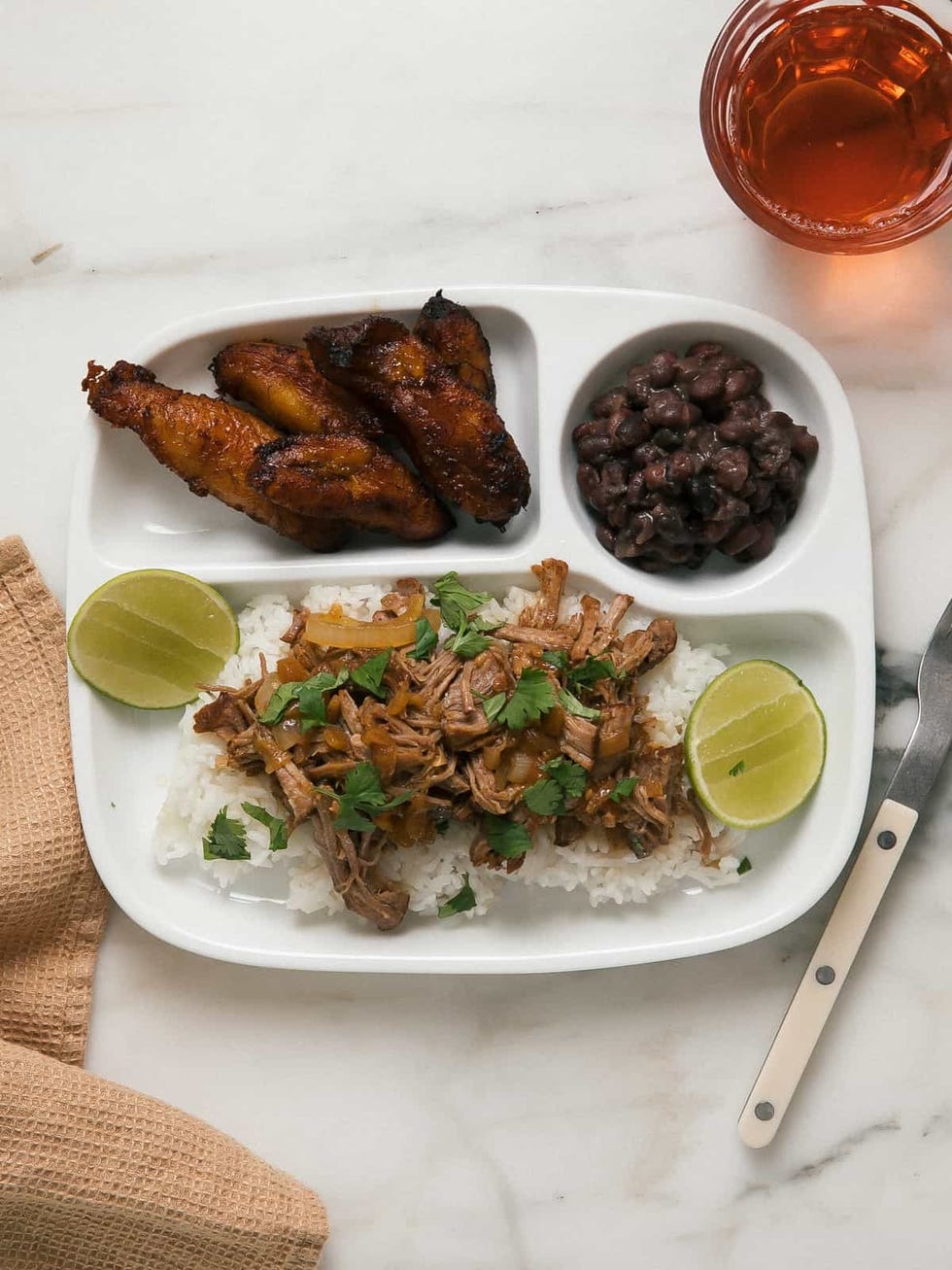 lechon asado on white rice and fried plantains on the side