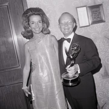 lee radziwill standing next to truman capote who is holding an emmy trophy and the both of them smiling