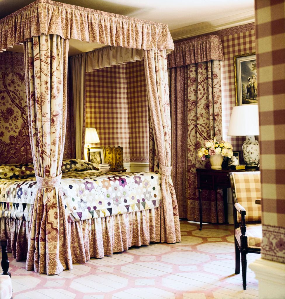 vogue, july 01, 1971   lee radziwills bedroom in the country home she shares with prince stanislaw and their two children, turville grange, buckinghamshire, england the room features a canopy bed made of pink floral and paisley linen toile, a silk taffeta patchwork quilt covering the bed, silk taffeta squares covering the walls, and a pink and white stenciled wood floor the same pink check that covers the walls covers a side chair, and a table stands against a wall with a lamp and a vase of flowers on it on the bedside table there is a lamp, a framed print, and some books horst p horstconde nast via getty images