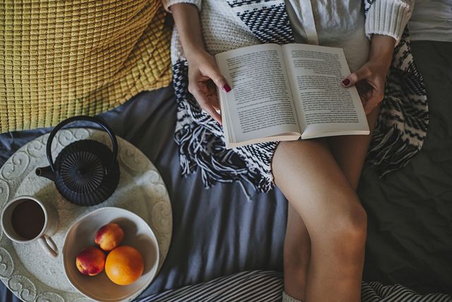 Vrouw leest boek op bed