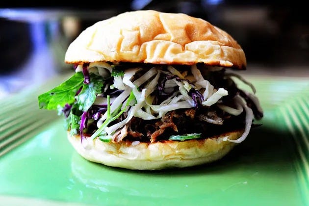 pork sandwiches with cilantro jalapeno slaw on green plate