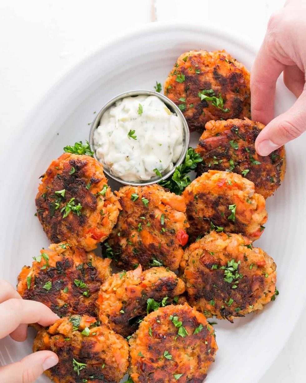 salmon cakes with dip and hands