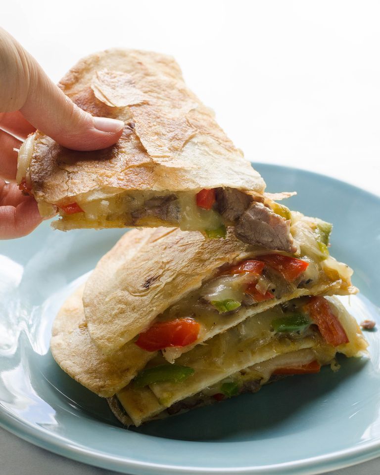 leftover steak recipes cheesesteak quesadillas stacked on blue plate