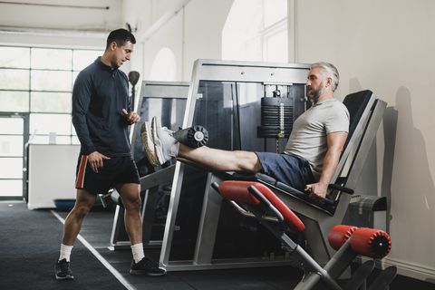 Leg Extensions with Personal Trainer in the Gym