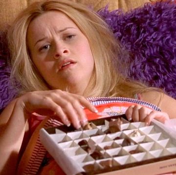 elle woods reese witherspoon lying in bed with a box of chocolates