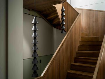 two black cone pendant strings hanging in a stairwell