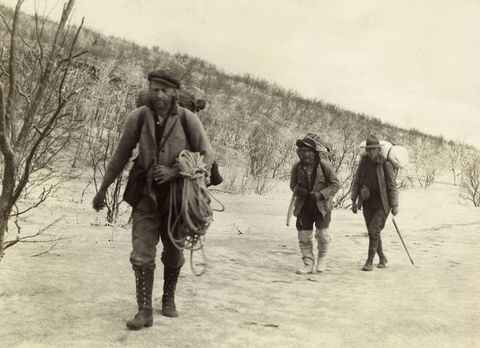 Expeditieleden dragen goederen door de Valley of Ten Thousand Smokes in Alaska Na de uitbarsting van de Novarupta in 1912 was het gebied bedekt met vulkanische as en moesten veel bewoners hun huizen verlaten